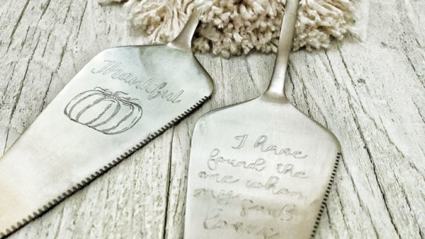 Two stainless steel servers with text engravings