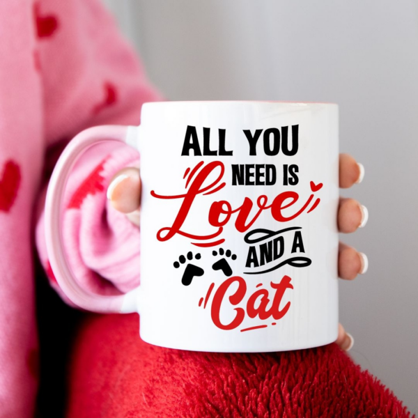 All you need is love and a cat SVG design cut out in black and red vinyl and placed onto a white mug