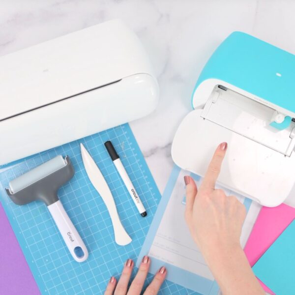 Abbi Kirsten's hands pointing to the Cricut Joy and Joy Xtra machines