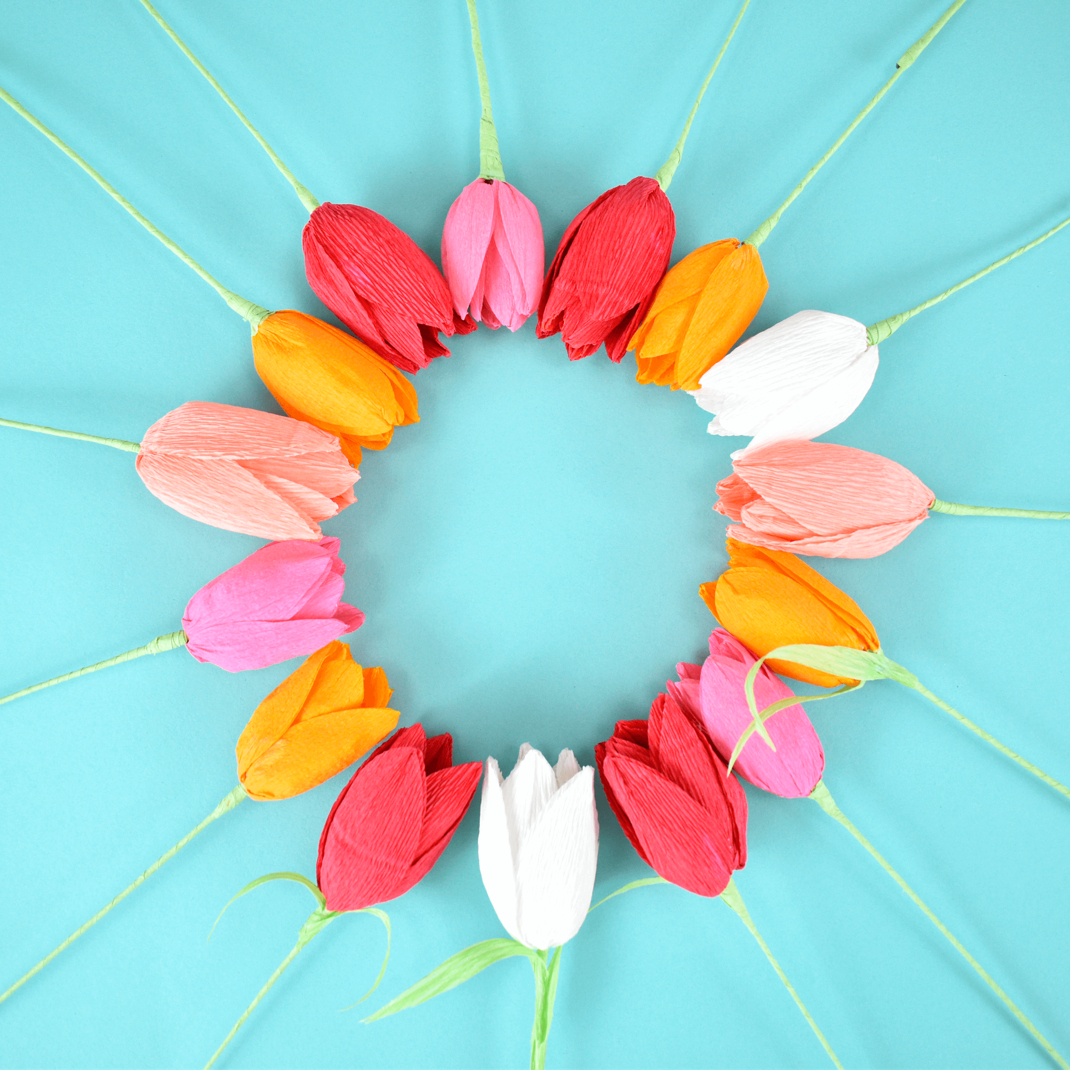 Colorful crepe paper tulips on a blue background