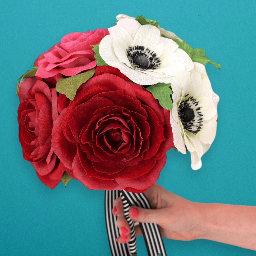 Crepe paper flower bouquet made up of red roses and white and black anemones