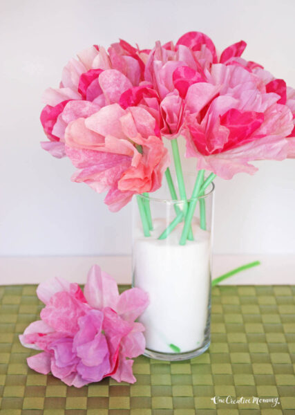 Pink flowers made from coffee filters with green stems in a vase